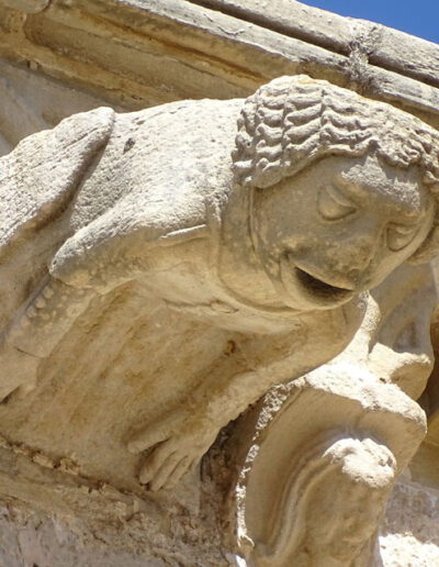 Gárgola de la Iglesia de Santa María la Mayor de Valderrobres (Teruel). Es una figura humana: una mujer con vestido abotonado. Está en el costado meridional de la iglesia.